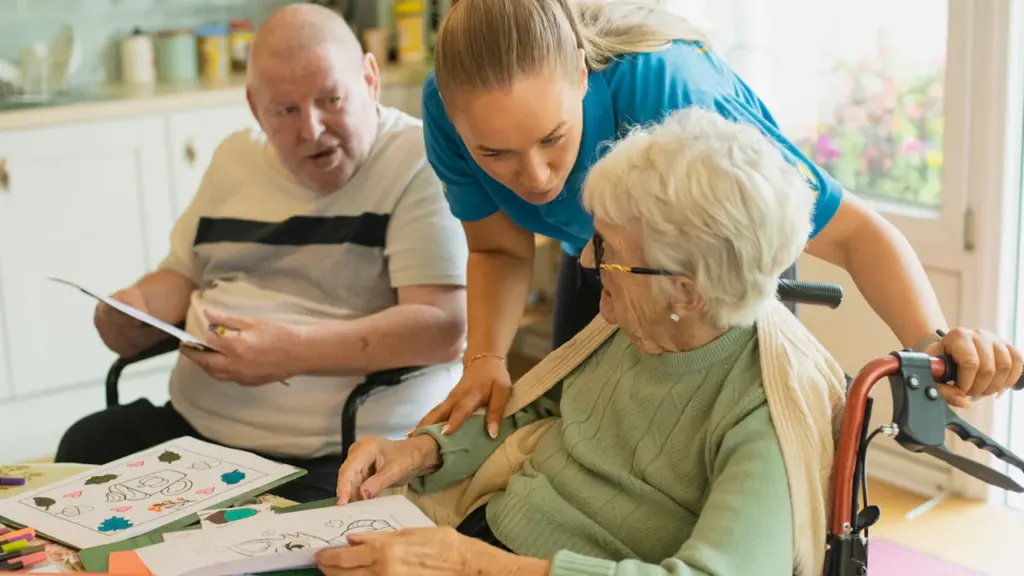 Trabajadora social asistiendo a personas mayores en actividades de estimulación cognitiva en Cáceres.