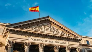 Fachada del Congreso de los Diputados en Madrid con bandera española ondeando.