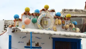 Detalle decorativo de boyas pesqueras en una fachada costera tradicional en España.