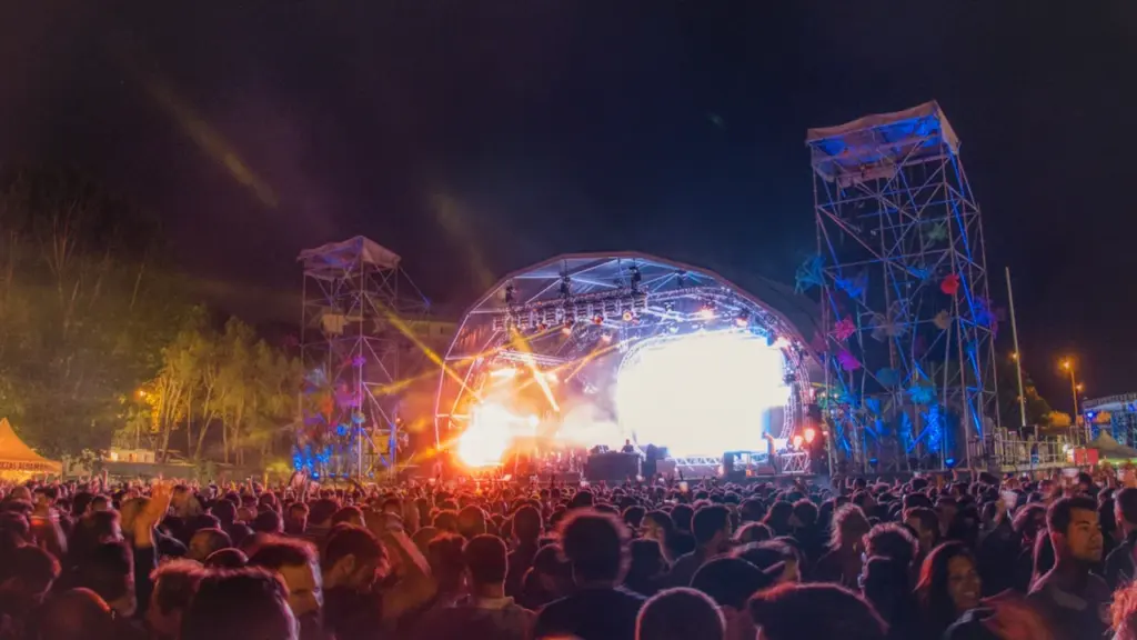 Multitud disfrutando de un festival de música en directo al aire libre en España.