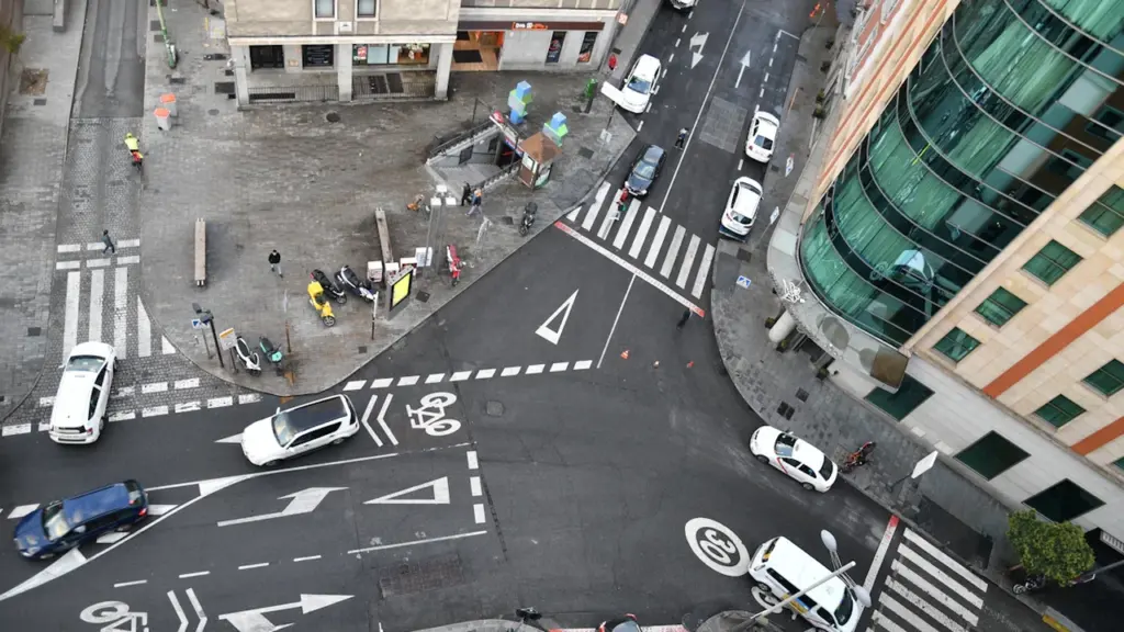 Vista aérea de un cruce urbano con coches y motocicletas en Madrid, España.