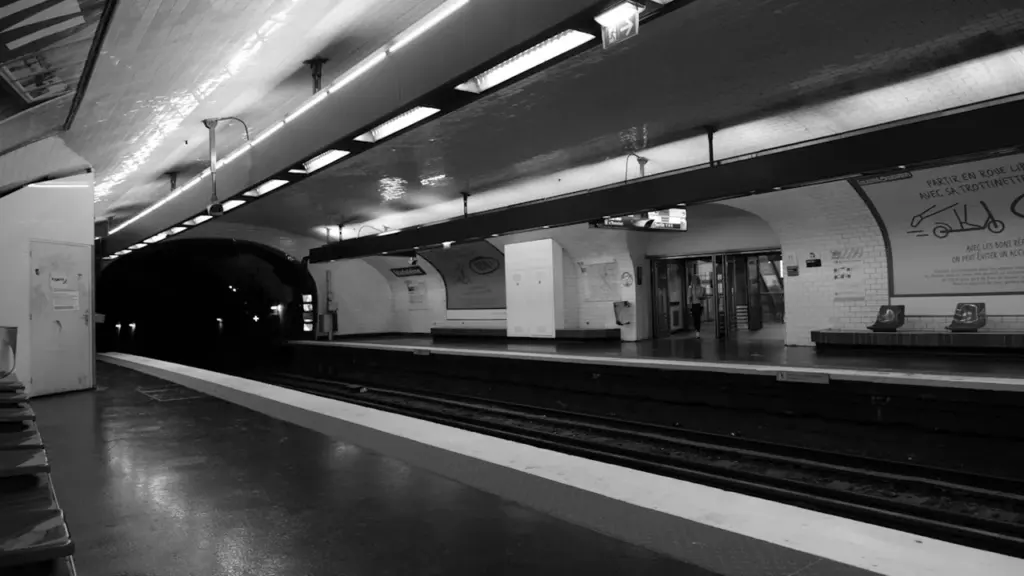Vista en blanco y negro de una estación de metro solitaria y subterránea.