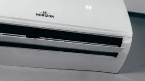 Unidad de aire acondicionado blanca mostrando una temperatura de 22 grados en pantalla.