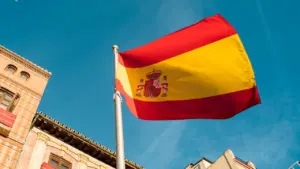 La bandera de España ondeando sobre un edificio gubernamental en un día despejado.
