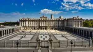 Vista panorámica del Palacio Real de Madrid bajo un cielo azul despejado.