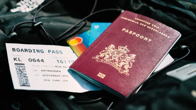 Pasaporte y tarjeta de embarque listos para viajar en una bolsa de mano.