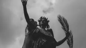 Estatua clásica sosteniendo hoja de palma, símbolo estoico de victoria sobre la adversidad.
