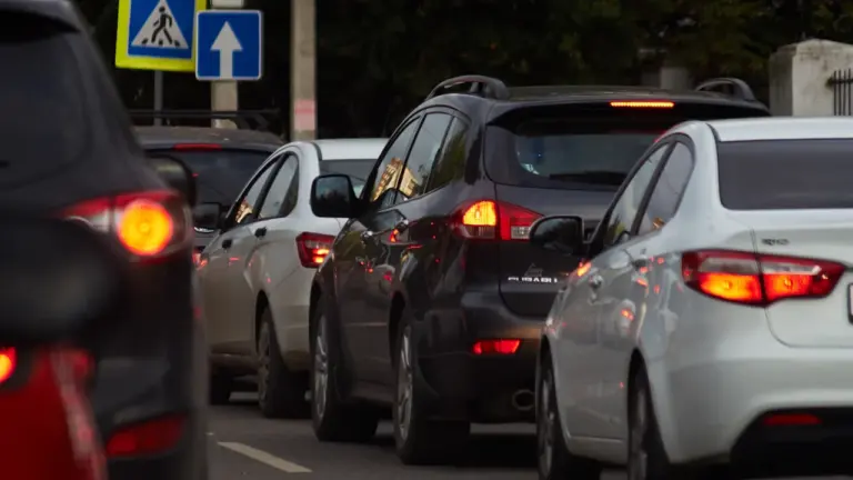 Coches circulando por una carretera urbana durante el día.