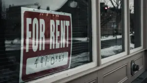 Cartel de 'se alquila' en el escaparate de una vivienda urbana.