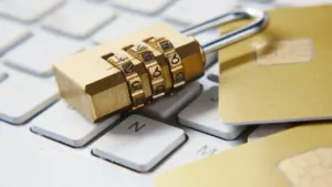 Un candado de seguridad sobre un teclado de ordenador con tarjetas bancarias.
