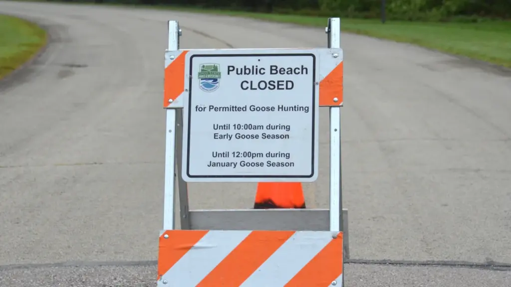 Señal de tráfico portátil que indica que la playa pública está cerrada actualmente.