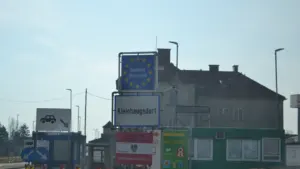 Puesto de control fronterizo con banderas europeas y señalización oficial en carretera.