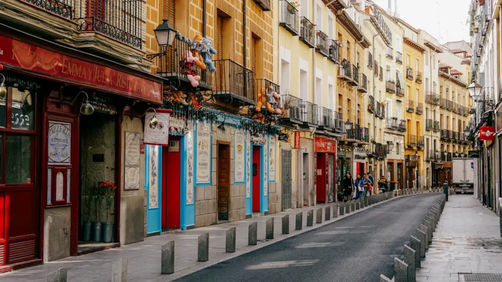 Calle tradicional española con edificios encalados y macetas, ideal para inversiones comerciales.