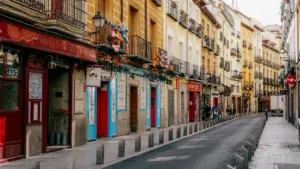 Calle tradicional española con edificios encalados y macetas, ideal para inversiones comerciales.