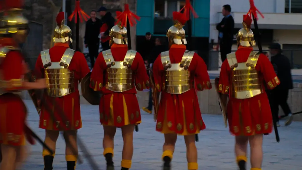 Grupo de personas disfrazadas de soldados romanos marchando en una plaza de Banyoles.