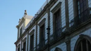 Fachada de un edificio histórico de arquitectura clásica bajo un cielo azul despejado.