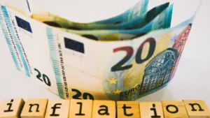 Billetes de euro y bloques de madera con la palabra inflación en español.