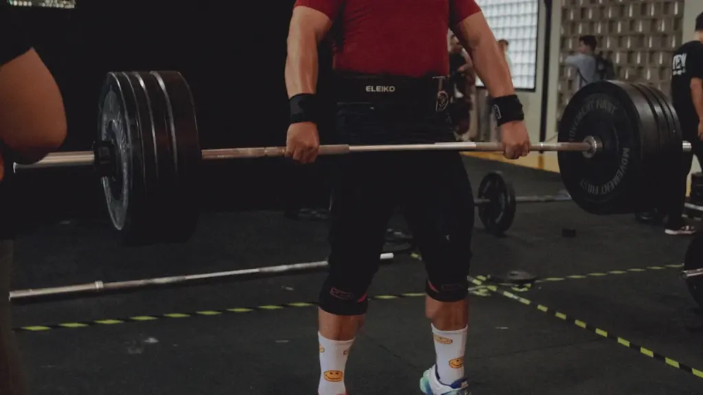 Un atleta levantando una barra pesada durante una competición de halterofilia intensa.