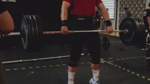 Un atleta levantando una barra pesada durante una competición de halterofilia intensa.