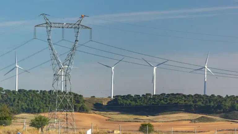 Aerogeneradores y torres de alta tensión en el paisaje rural de España.