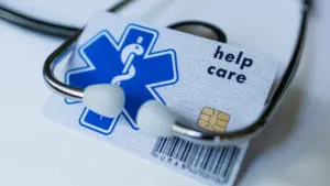 Tarjeta sanitaria europea junto a un estetoscopio médico para trámites internacionales.
