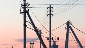 Postes eléctricos de alta tensión bajo un cielo despejado durante el día