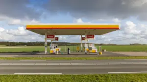 Gasolinera solitaria en una carretera despejada rodeada de campo en un día nublado.