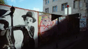 Un mural urbano que representa a Charlie Chaplin sobre una pared en una calle.