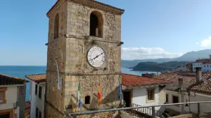 Torre del reloj en el pueblo costero de Lastres, Asturias, bajo el cielo español.