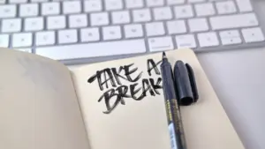 Un cuaderno con la frase take a break escrito junto a un teclado